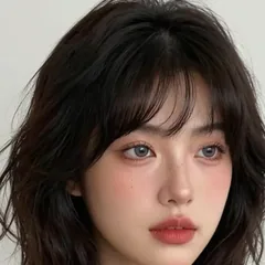 Woman with a short dark bob in a grey top