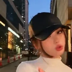 Young woman in a black cap and a white top